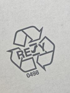 Eine Resy-Nummer zusammen mit dem Logo in schwarz gedruckt auf weiße Wellpappe.