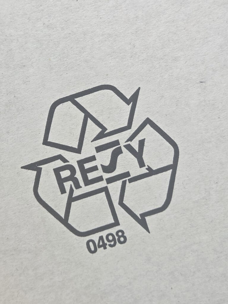 Eine Resy-Nummer zusammen mit dem Logo in schwarz gedruckt auf weiße Wellpappe.